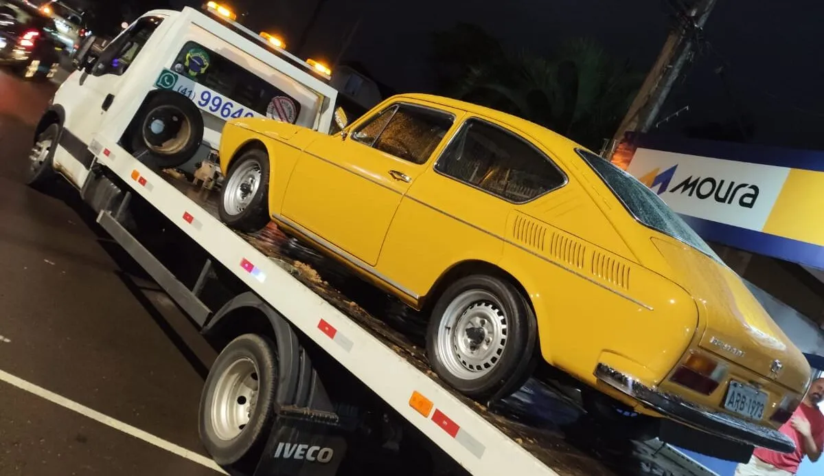 Guincho plataforma do Guincho Zeca transportando um Volkswagen amarelo à noite